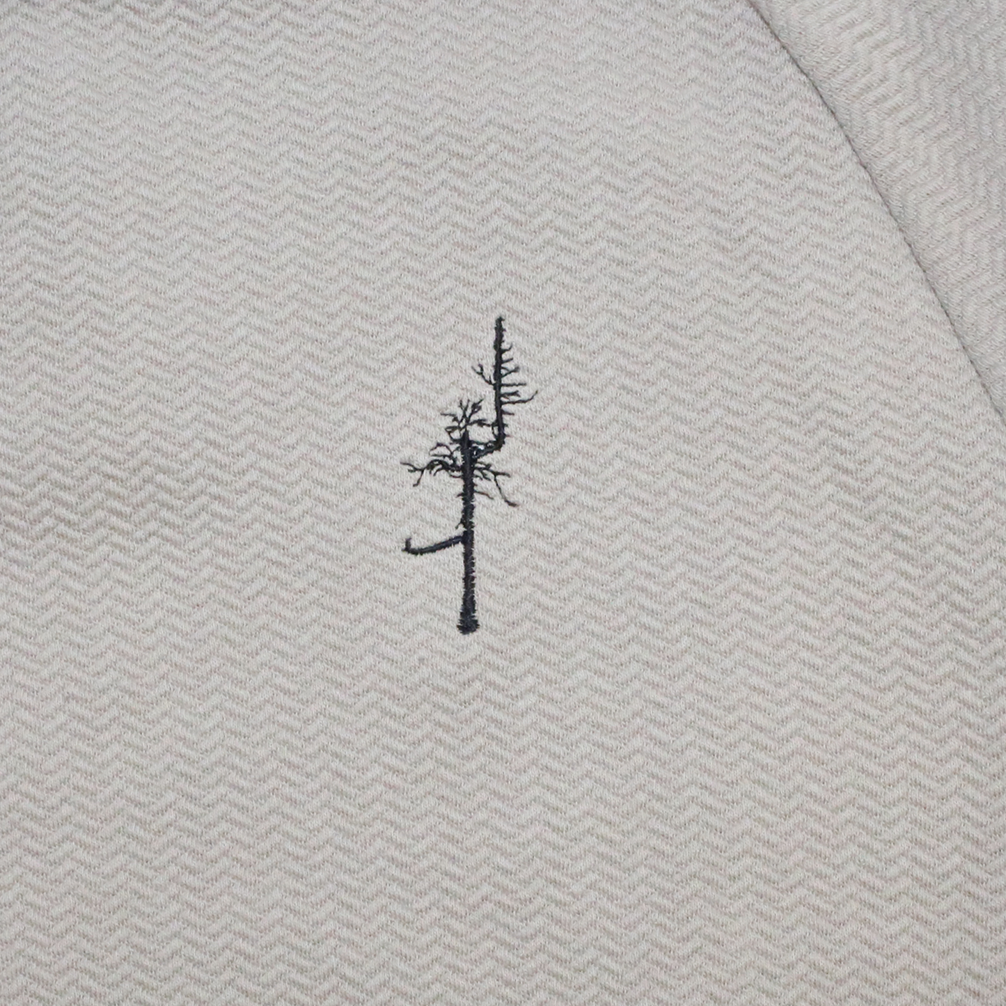 Black embroidery Ghost Tree on the tan texture left chest.