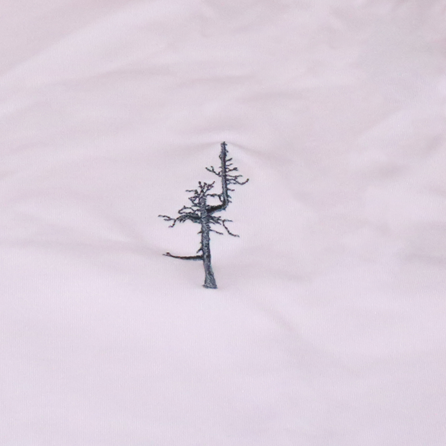 Close up of the pink fabric and the dark gray embroidered Ghost Tree.