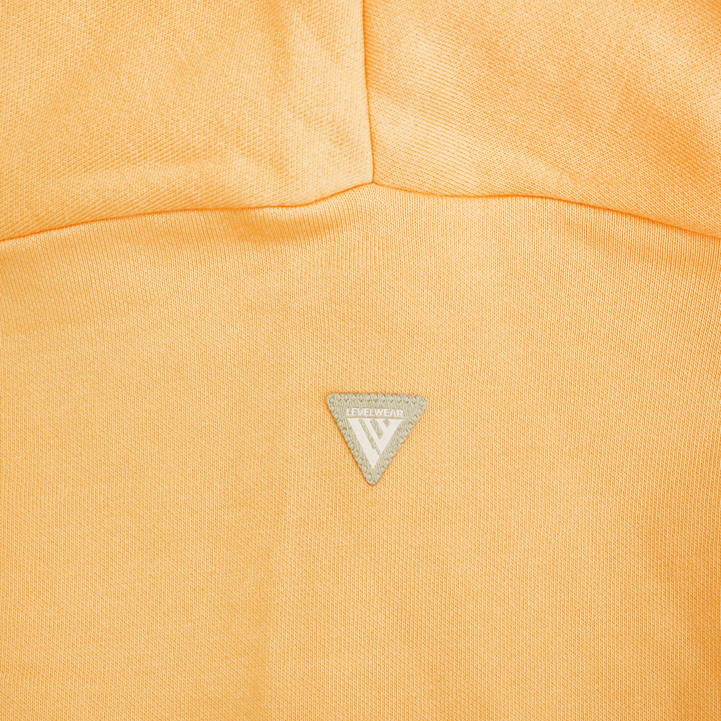 Close up of apricot fabric featuring: Levelwear logo.