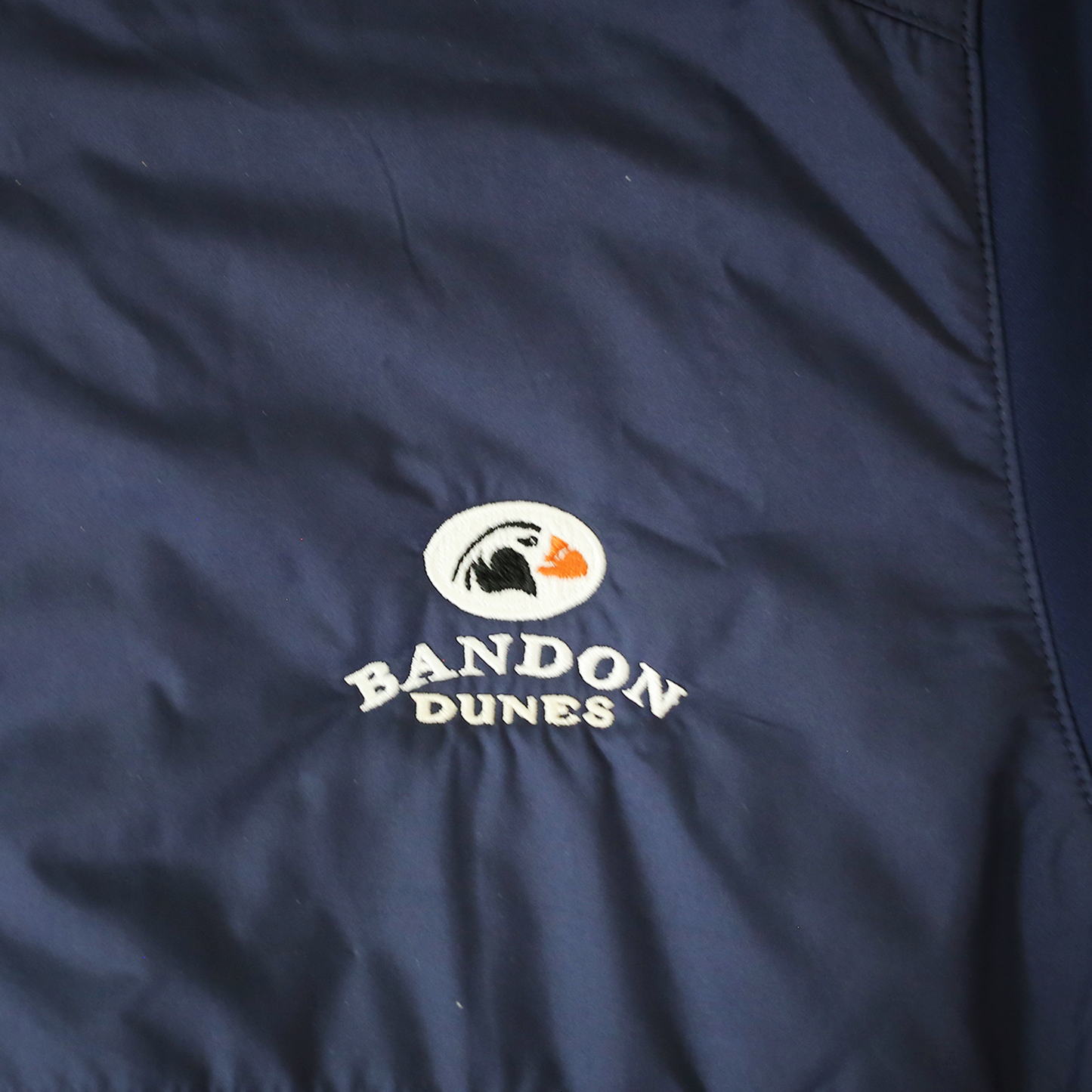 Close up navy fabric embroidered with the Bandon Dunes logo.
